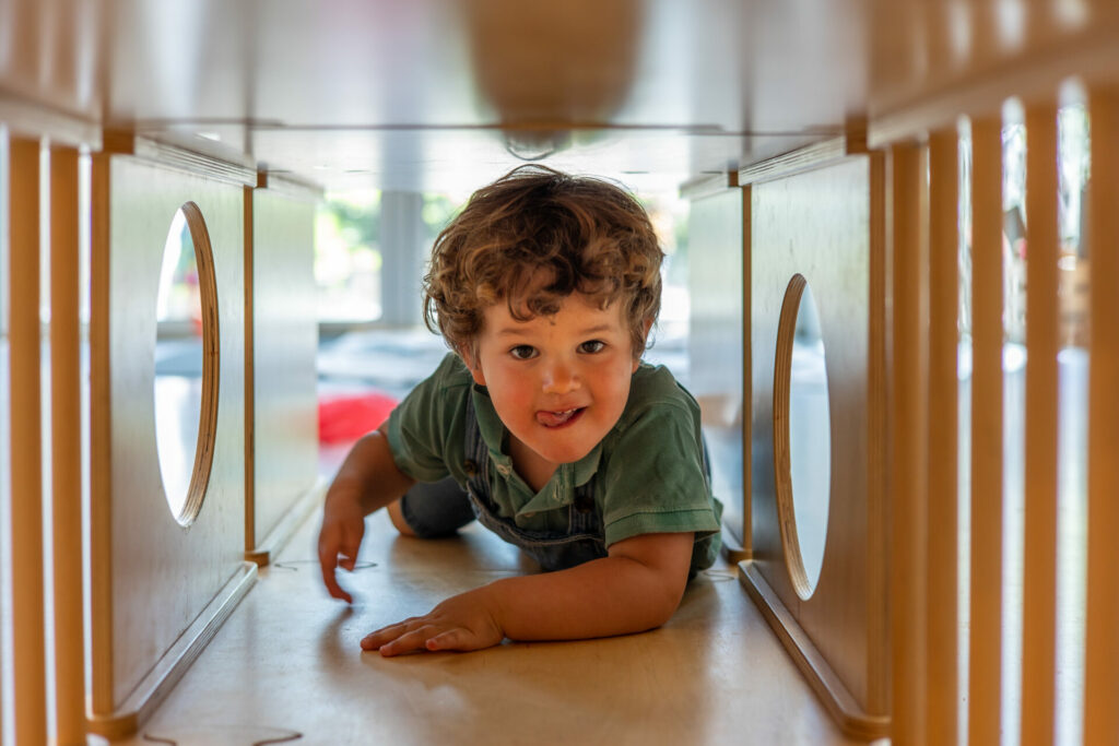 Jongen kruipt door tunnel op peuteropvang